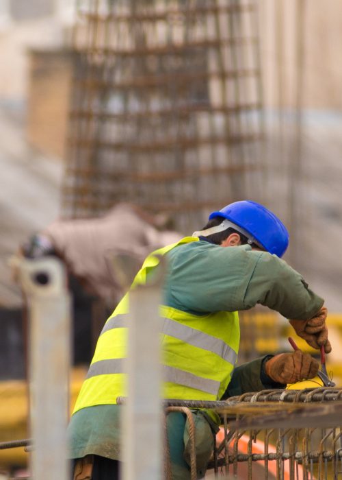 Worker repairing the armathure with pliers on construction site